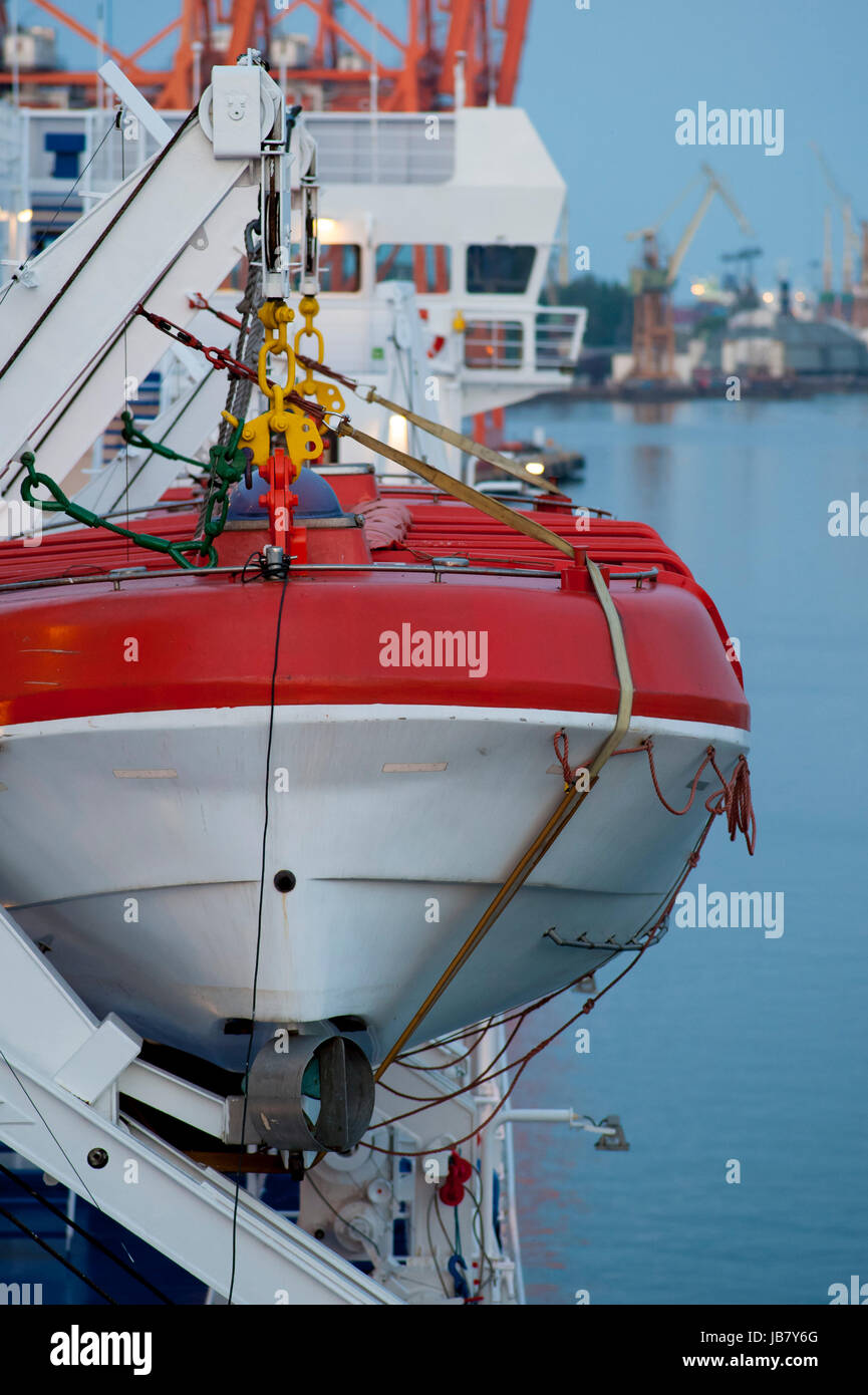Lifeboat Ropes White and red lifeboat, visible ropes and elements of the lift, in the ...