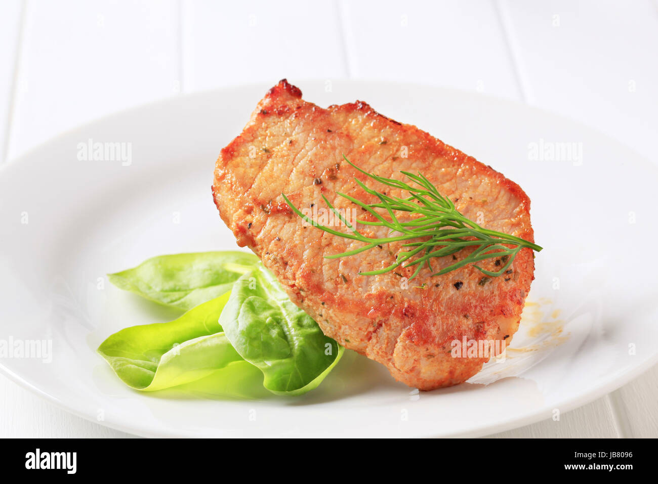 Marinated pork chop garnished with spinach leaves Stock Photo - Alamy