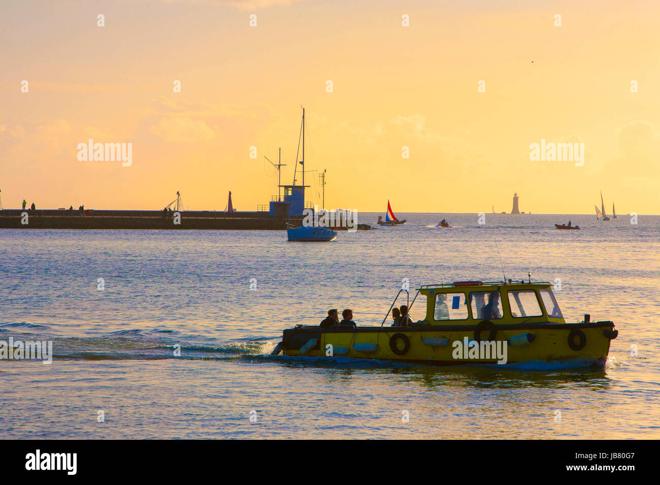 small yellow ferry boat sailing past pier at sunset Stock Photo - Alamy