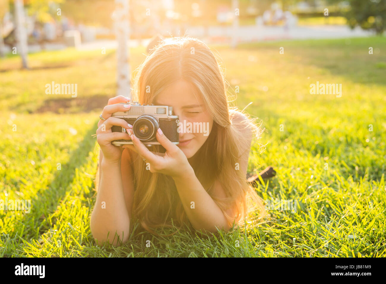Portrait of a young woman lying on the grass in sunlight Stock Photo ...