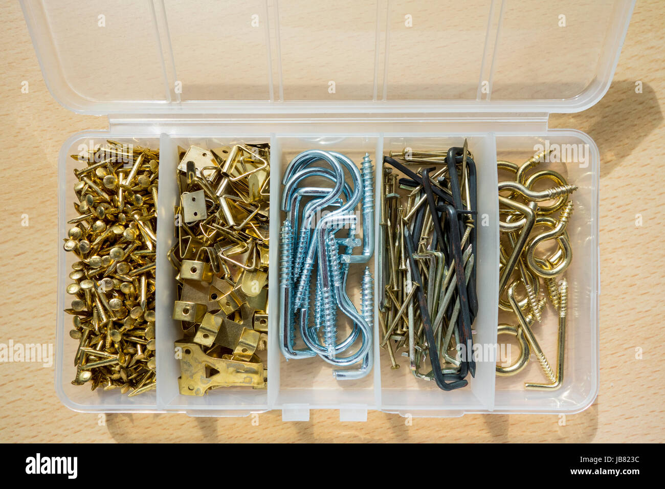 A handyman's box of assorted picture-hanging pins and hooks Stock Photo