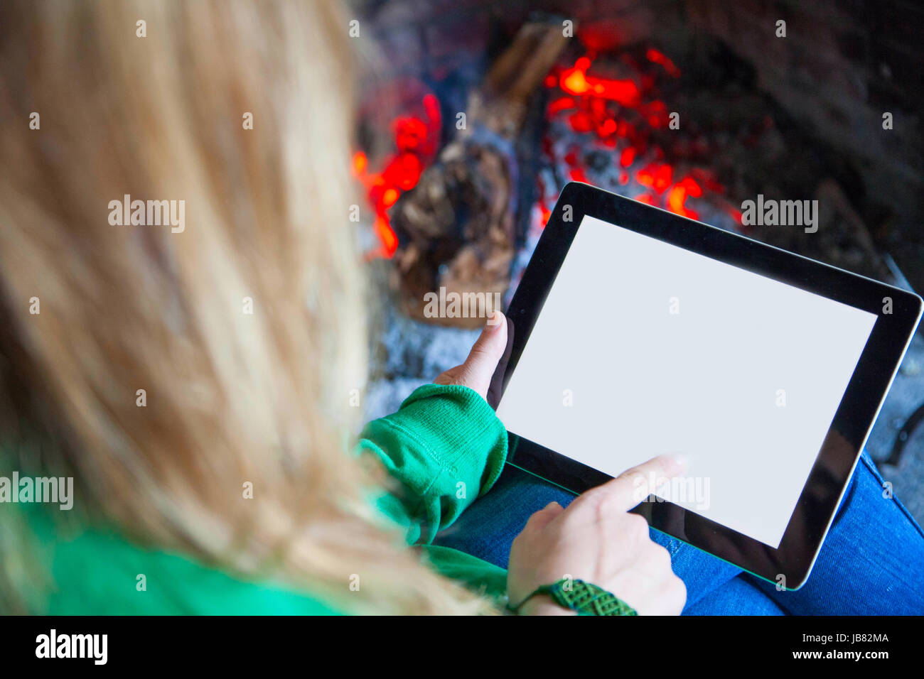 Woman with a tablet fire place and reading Stock Photo