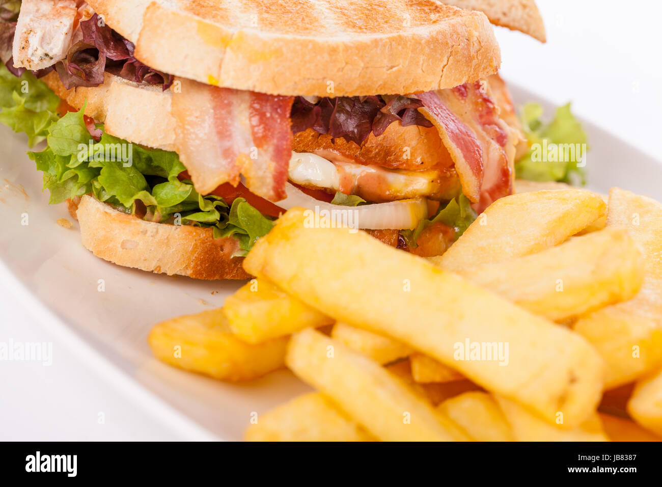 Clubsandwich auf getoastetem Weißbrot mit Speck und Pommes frittes ...