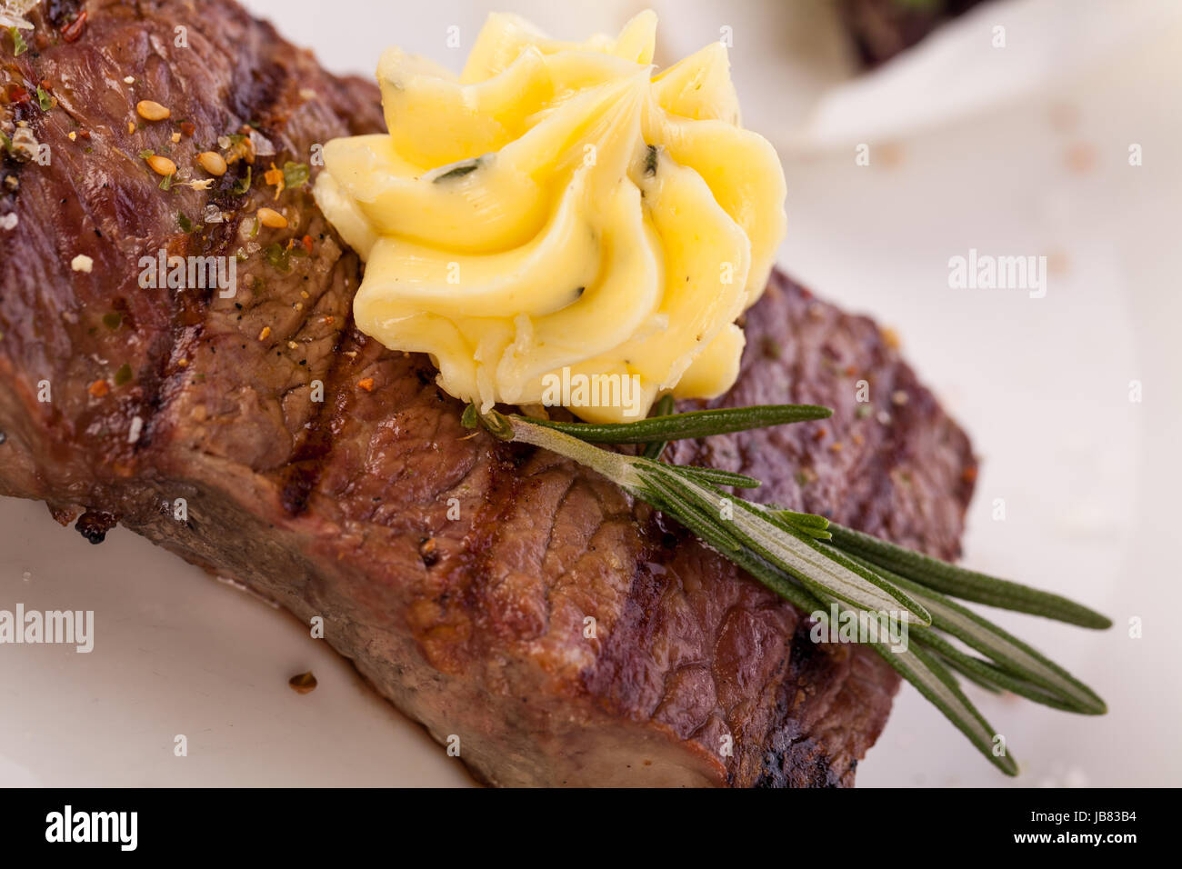 Saftig gegrillte Rinderfilet Steak mit hausgemachter Kräuterbutter auf einem Teller isoliert vor weißem Hintergrund Stock Photo