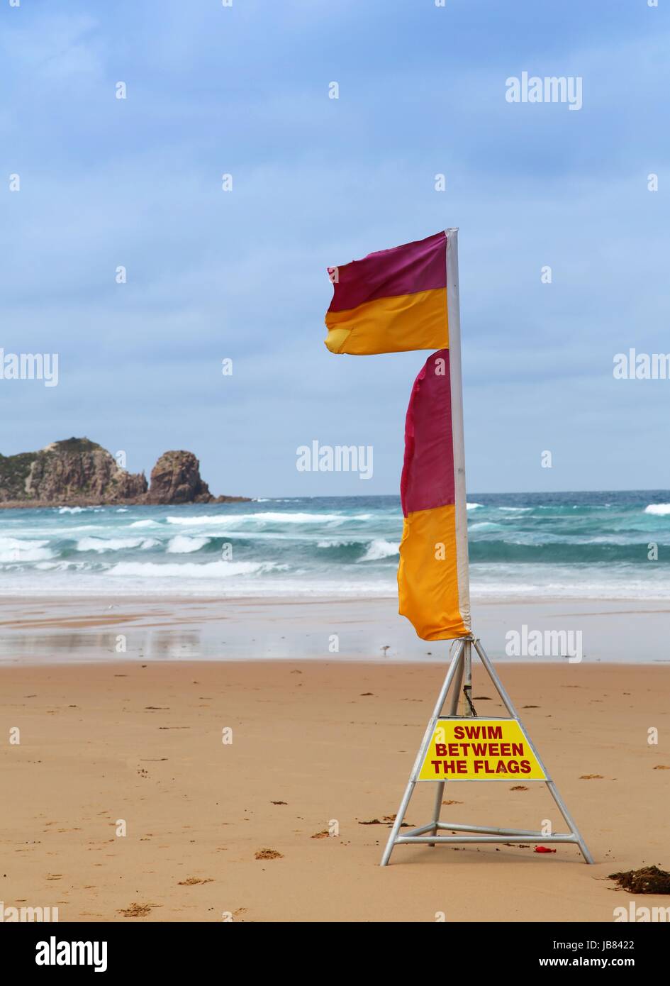 Surf lifesaving flags at the beach with warning to swim between the
