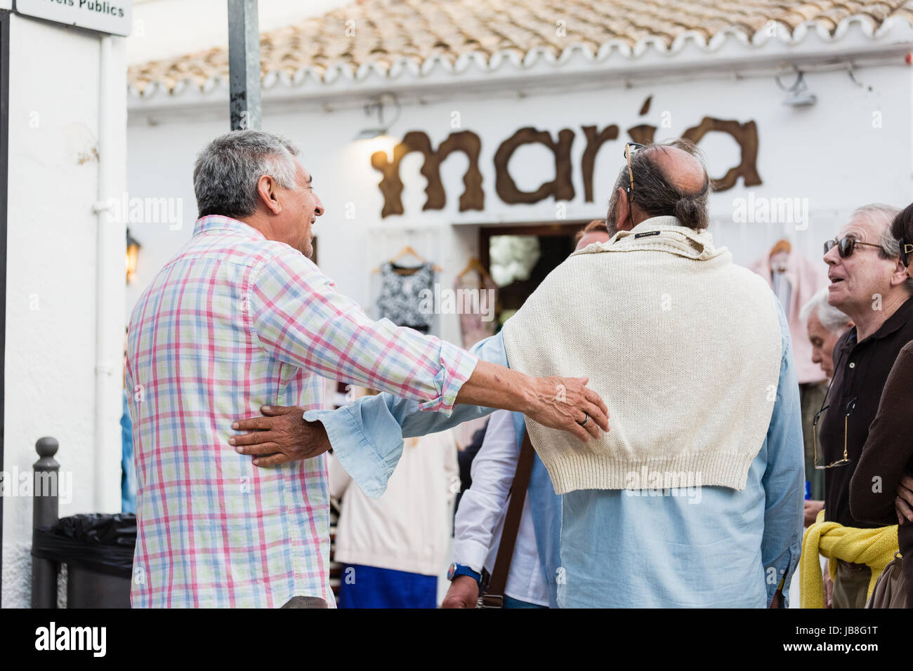 Two old men in contact with their arms, happy, showing their friendship Stock Photo