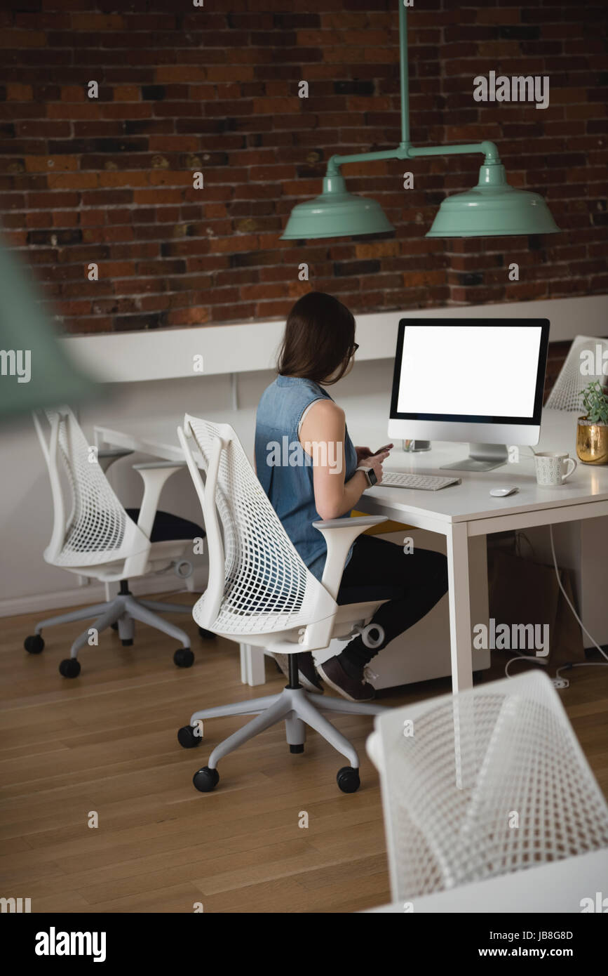 Rear view of executive using mobile phone in office Stock Photo - Alamy