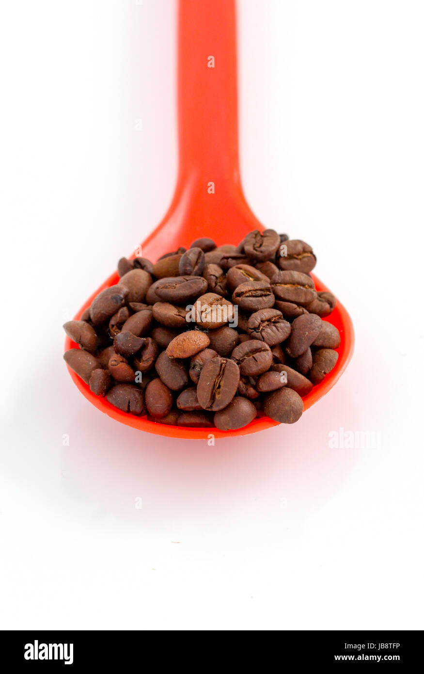 coffee beans in a plstic spoon on white background Stock Photo - Alamy