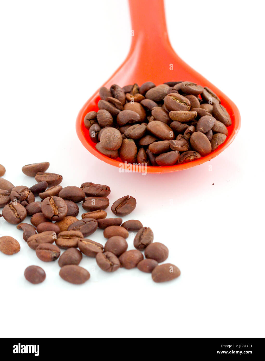 coffee beans in a plstic spoon on white background Stock Photo - Alamy