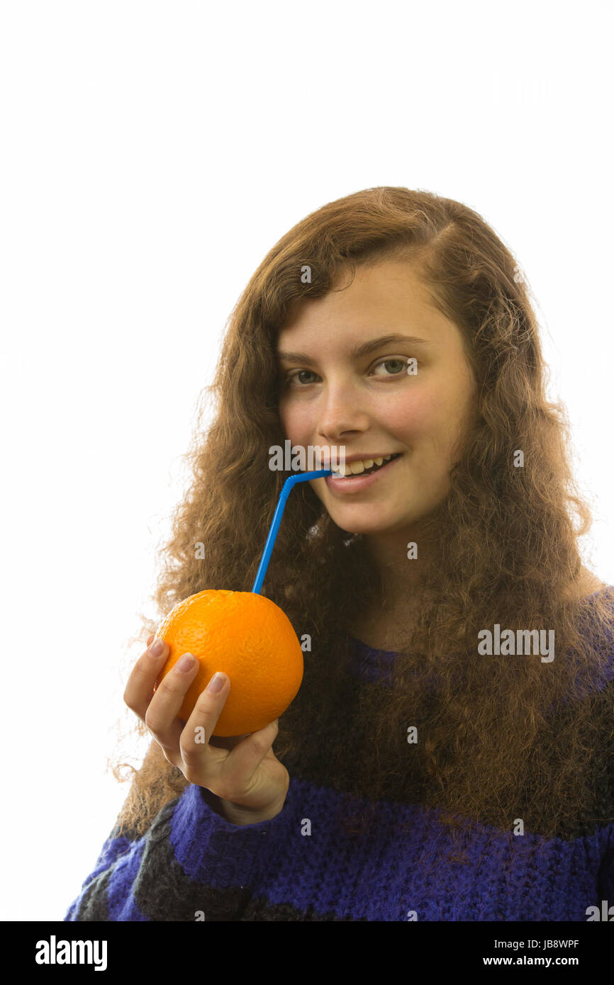 Eine junge hübsche Frau hält eine Orange mit Strohhalm in der Hand Stock Photo