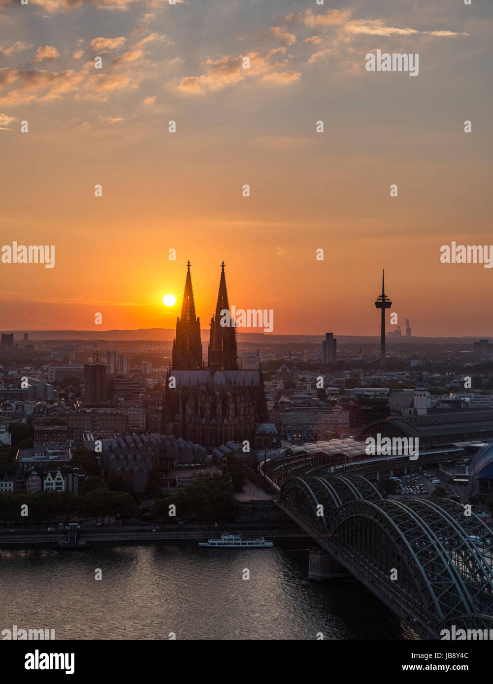 River Rhine at sunset, looking towards Cologne Cathedral (Kölner Dom) with Hohenzollern Bridge (Hohenzollernbrücke) in foreground, Cologne, Germany Stock Photo