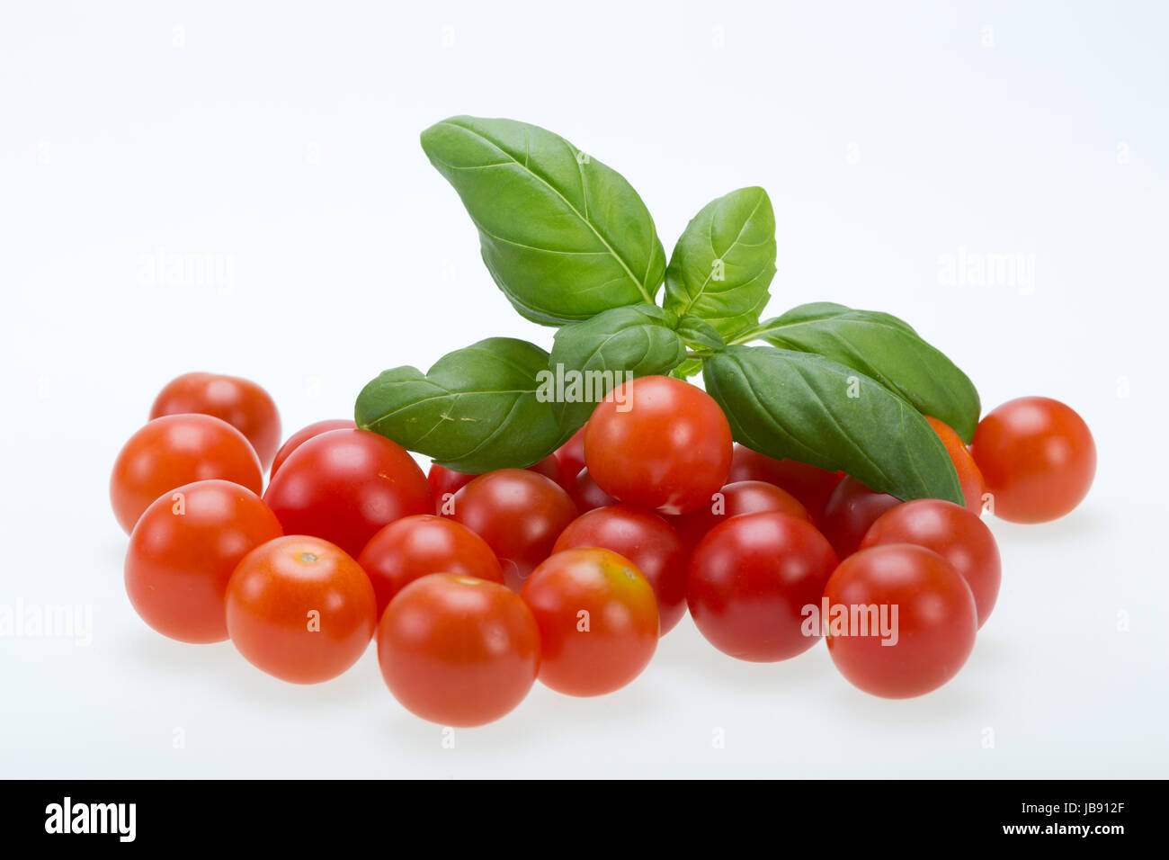 fresh cherry tomatoes with basil, on white background Stock Photo - Alamy