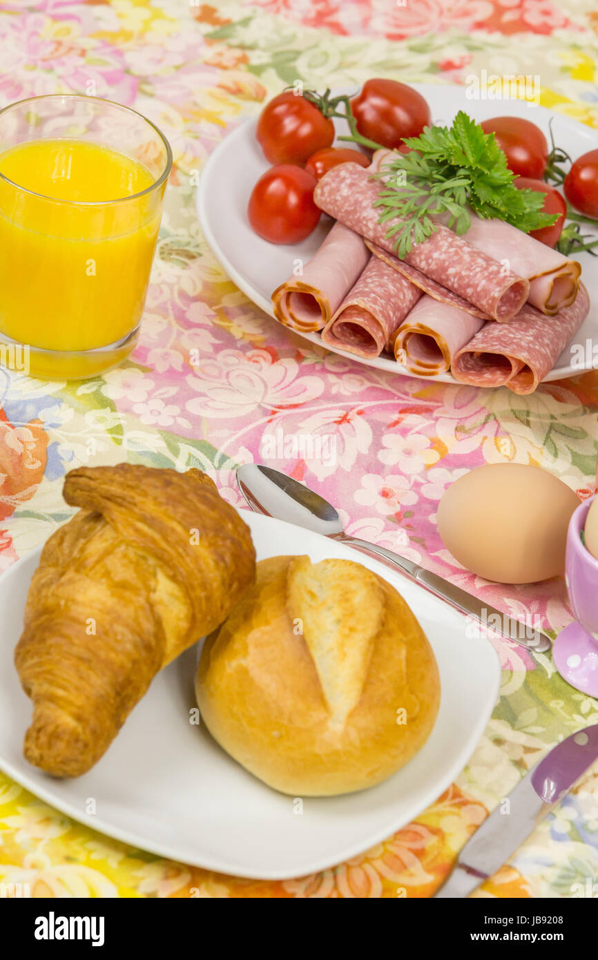 Frühstück mit Brötchen, Croissant, Ei und Aufschnitt Stock Photo