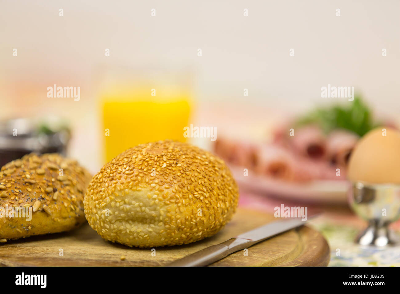 Frühstück mit Sesambrötchen, Croissant, Ei und Aufschnitt Stock Photo