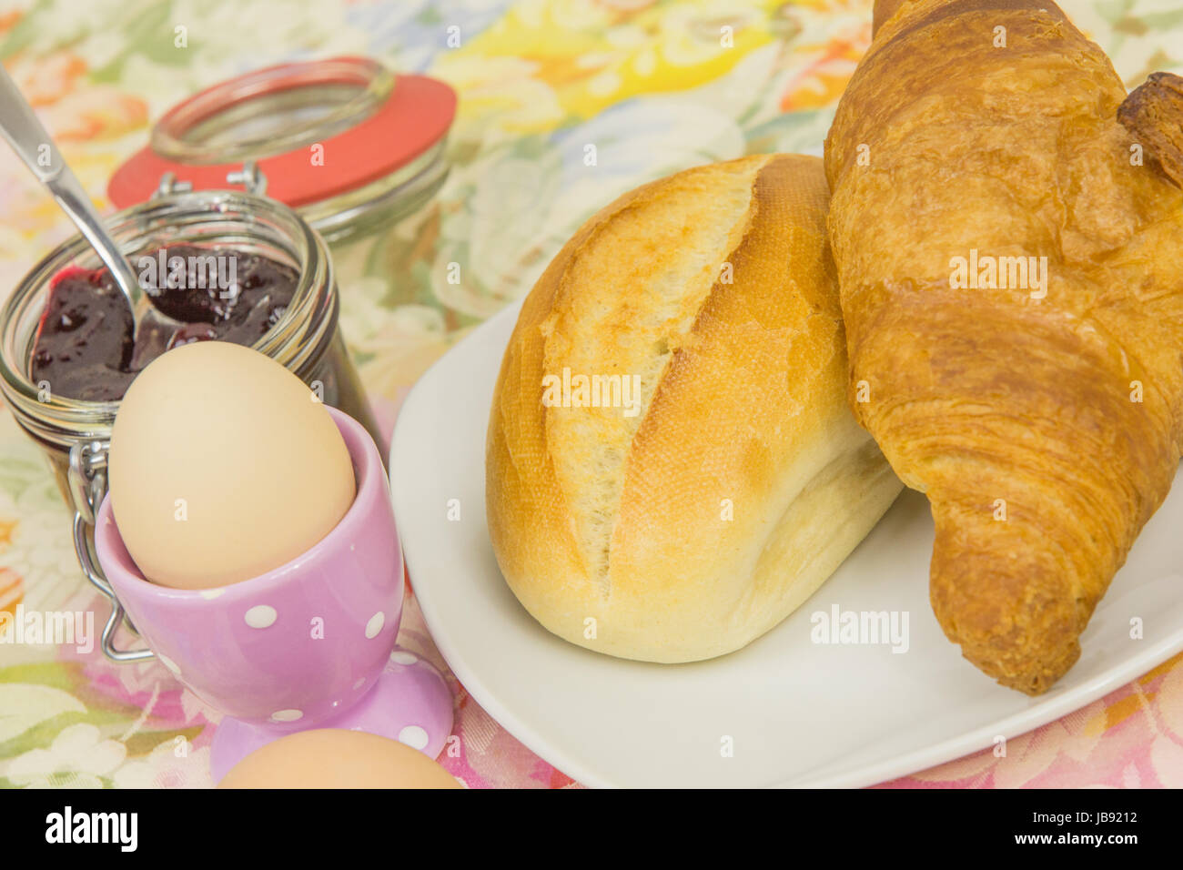 Frühstück mit Brötchen, Croissant, Ei und Marmelade Stock Photo