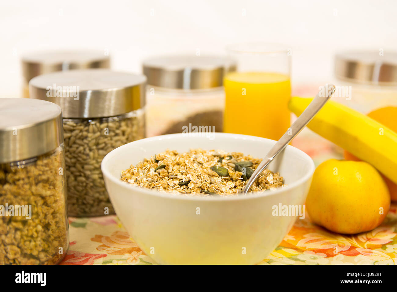 Müsli, Obst und Orangensaft auf einem Frühstückstisch Stock Photo