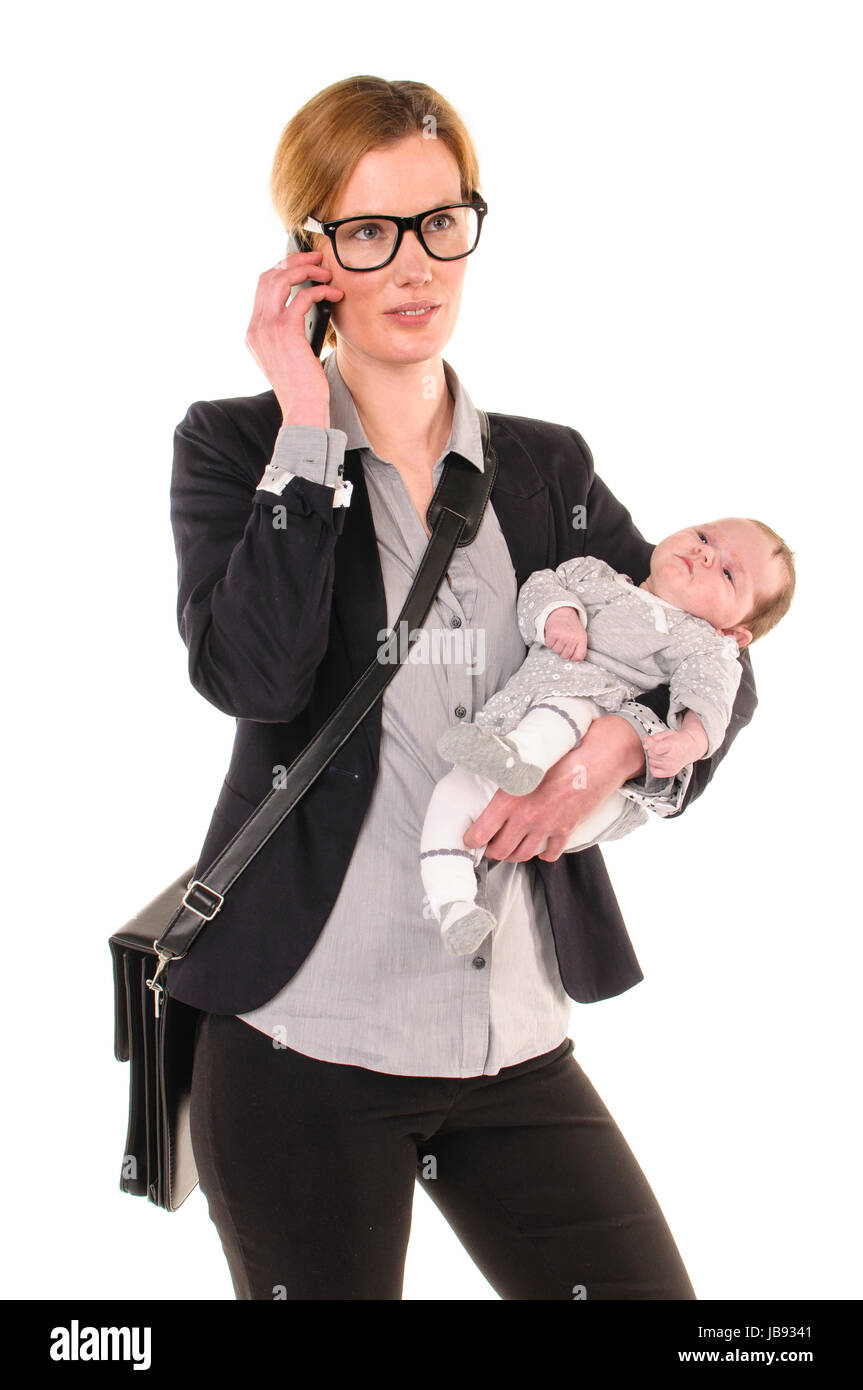 Erwachsene Geschäftsfrau Frau trägt Hemd und Jacket und hat einen Säugling im Arm während Sie mit dem Handy telefoniert, freigestellt vor weißem Hintergrund. Stock Photo