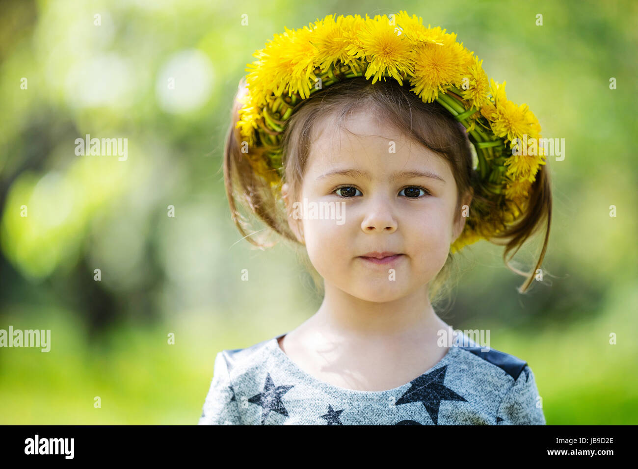 Cute little girl wearing wreath of dandelions in spring park Stock ...