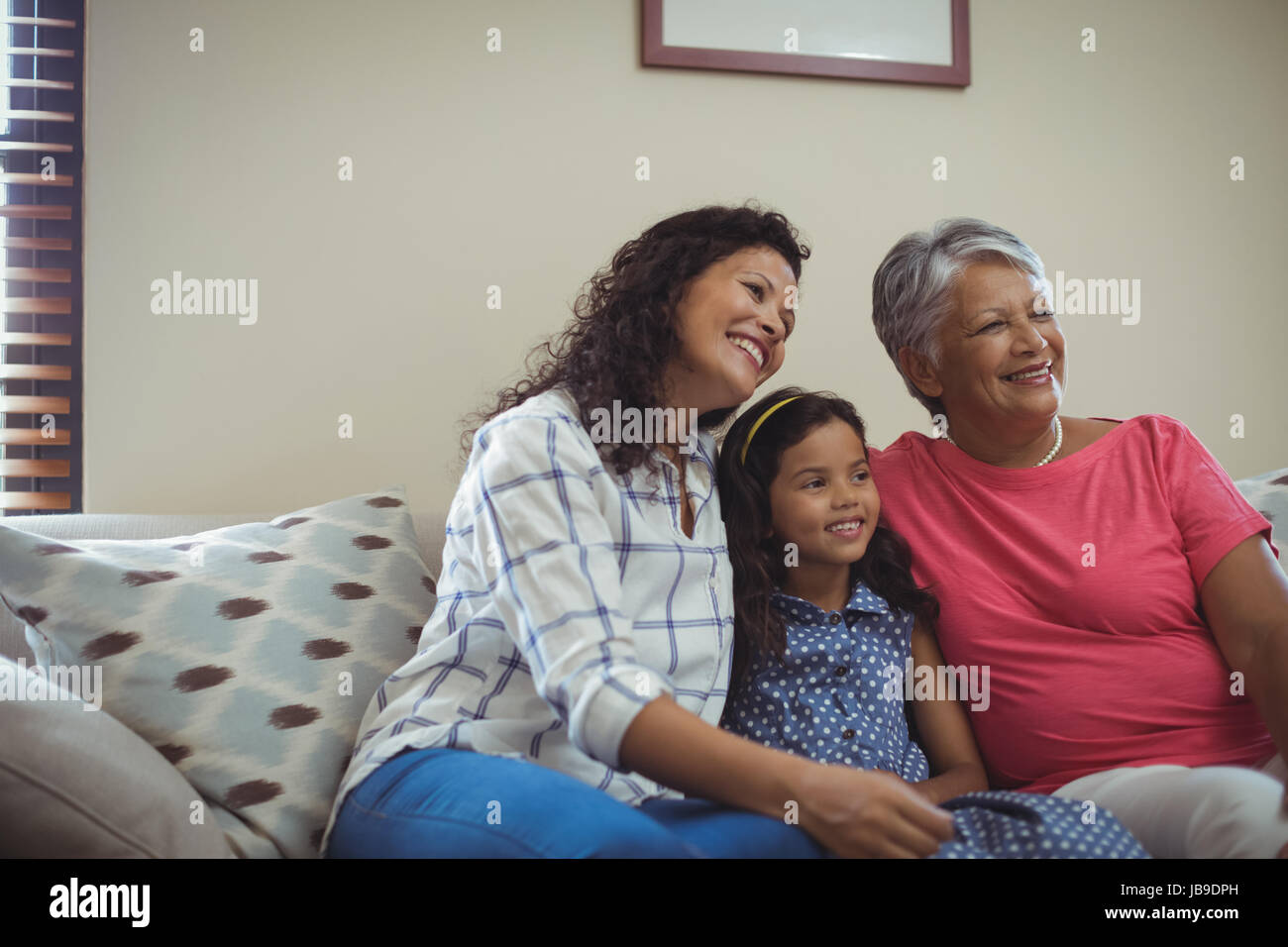 Happy family sitting on sofa in living room at home Stock Photo - Alamy