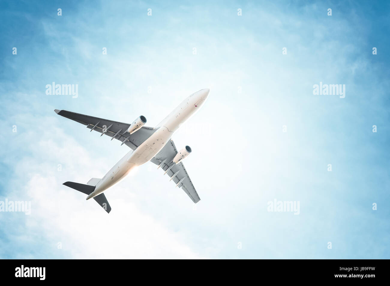 Airplane in the blue sky and clouds Stock Photo - Alamy