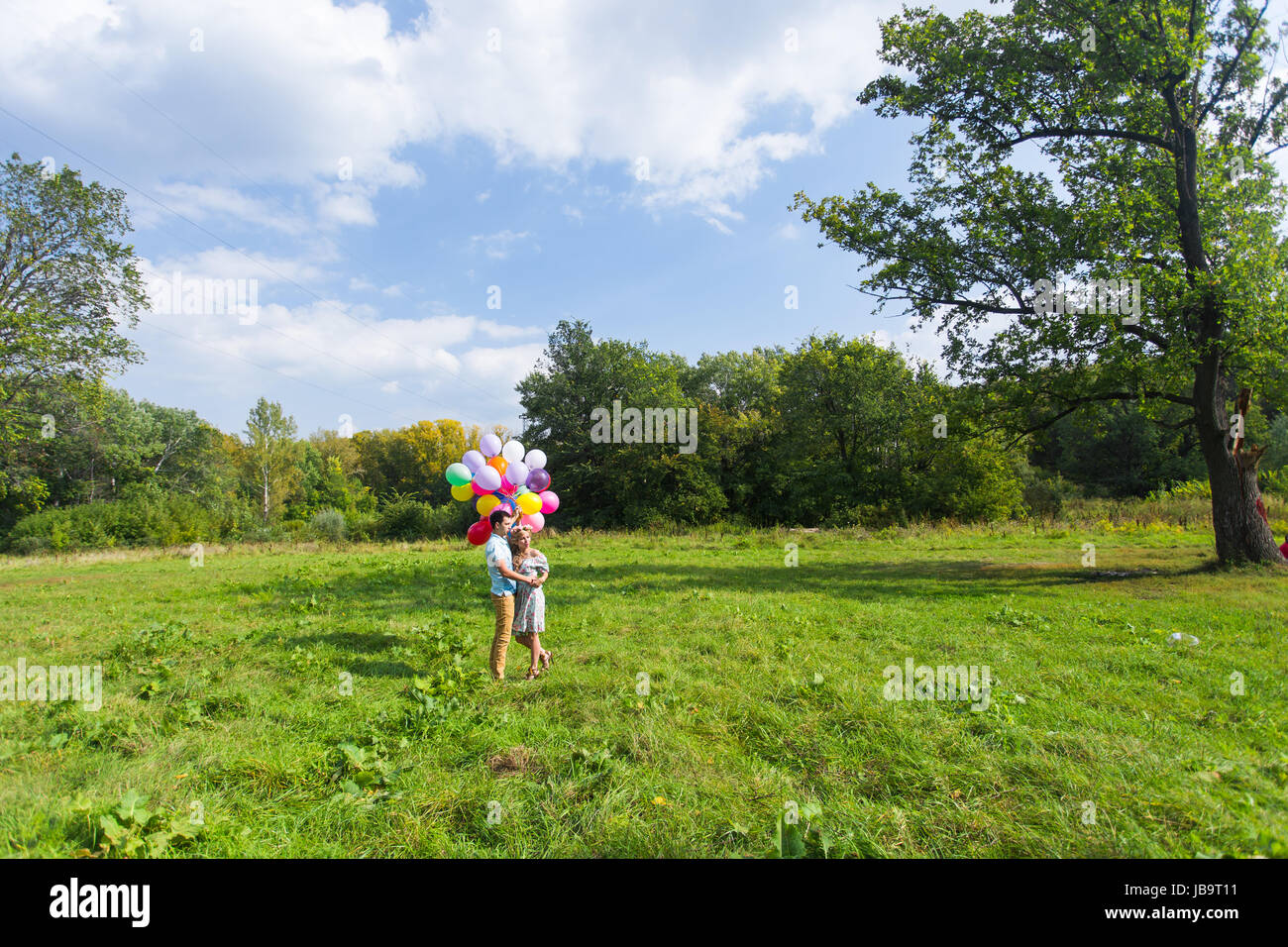 smiling couple in love with balloons in nature Stock Photo - Alamy