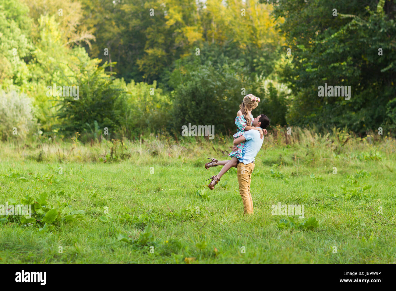 A couple in love beautiful young men and woman hugging in a summer park ...