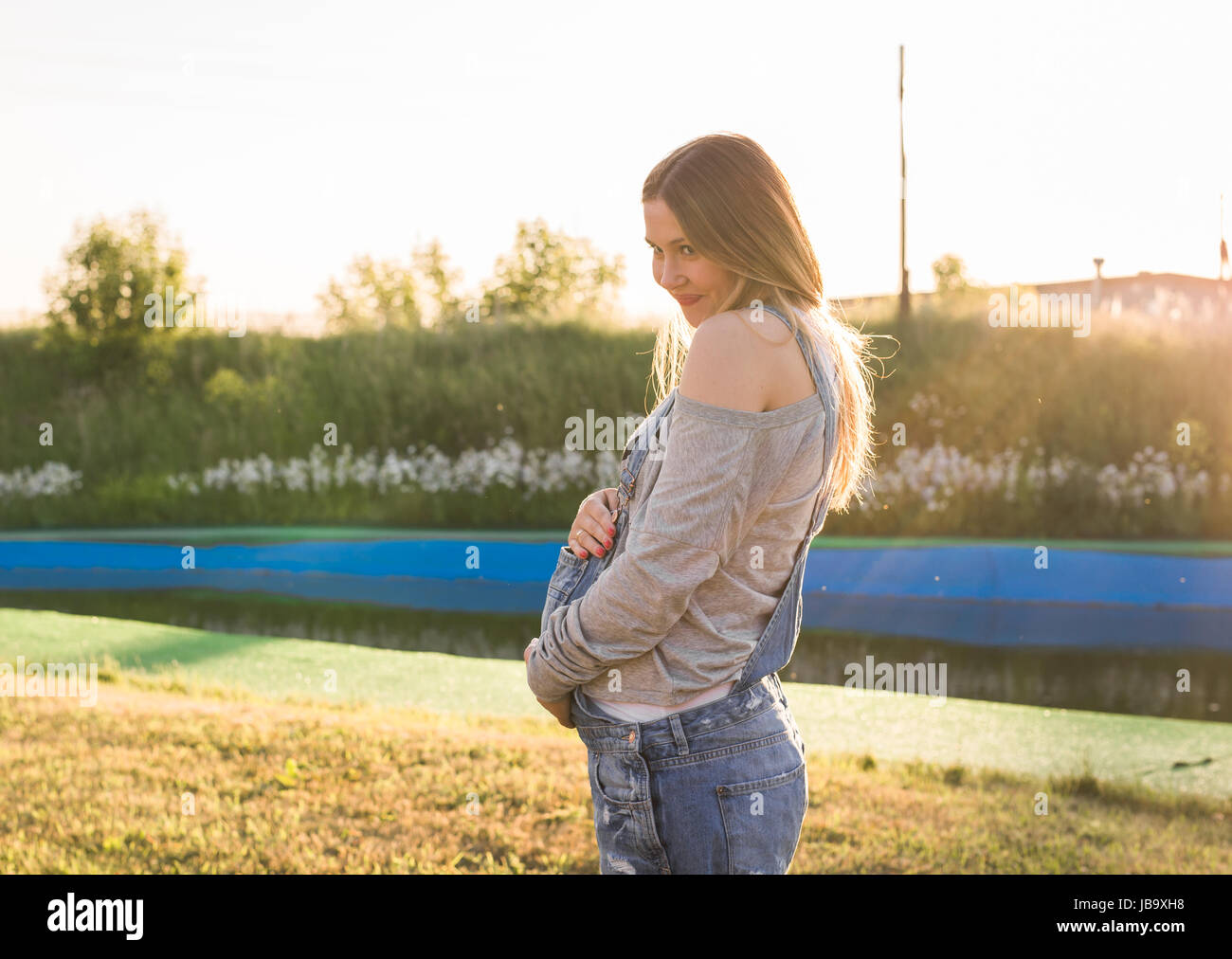 Pregnant woman hugging her stomach outdoors Stock Photo - Alamy