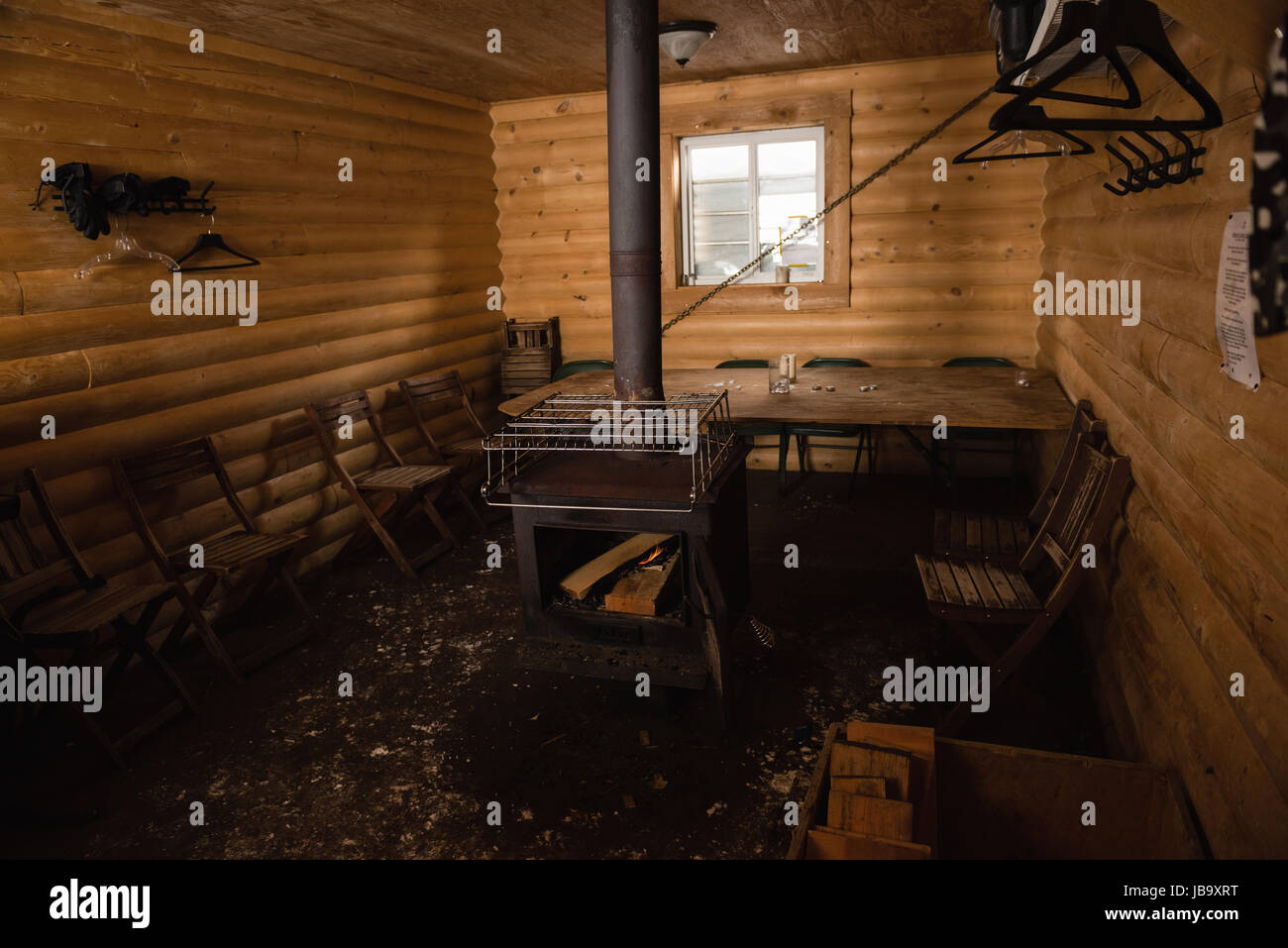 Empty Log Cabin With Chairs And Wood Burning Stove Stock Photo