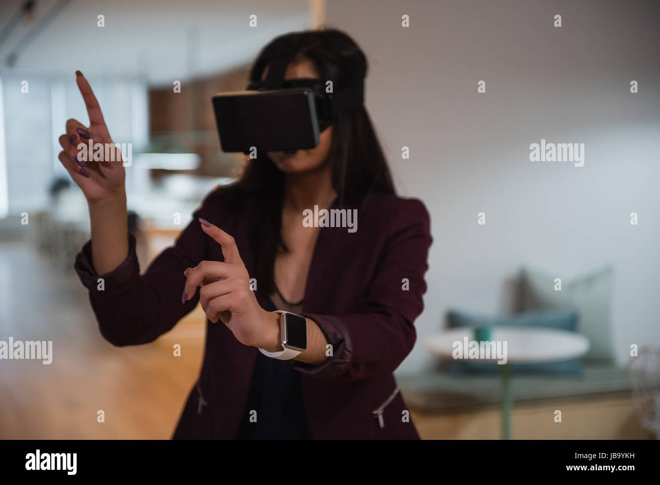 Female executive using virtual reality headset in office Stock Photo ...