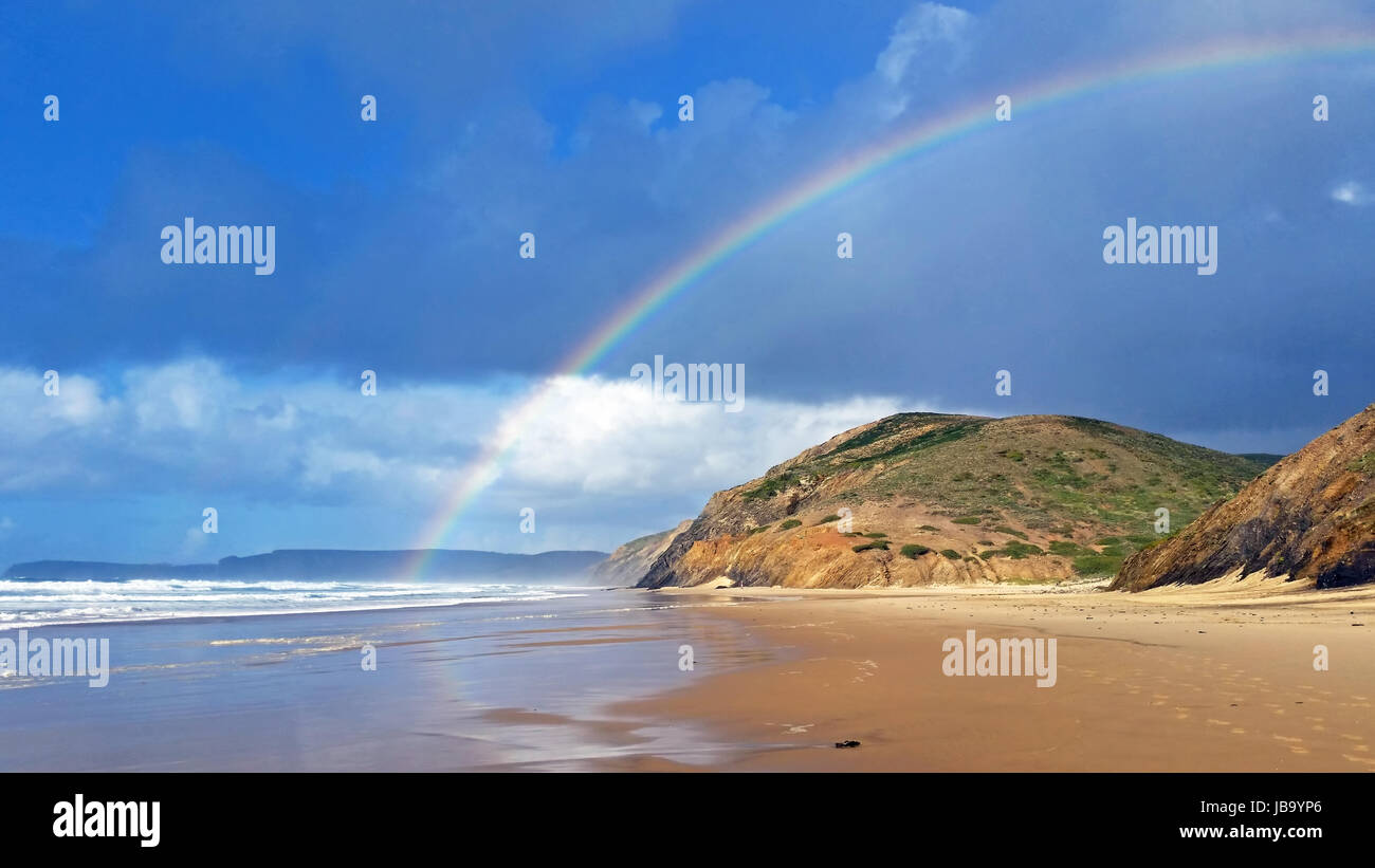 Rainbow on Vale Figueiras beach in Portugal Stock Photo