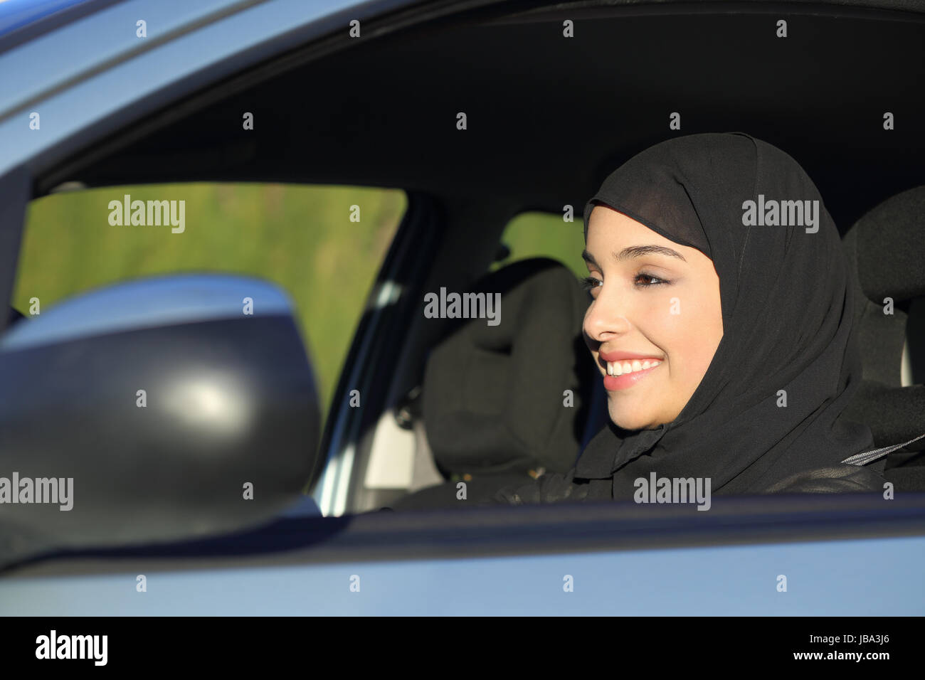 Happy arab saudi woman driving a car smiling with a headscarf Stock ...