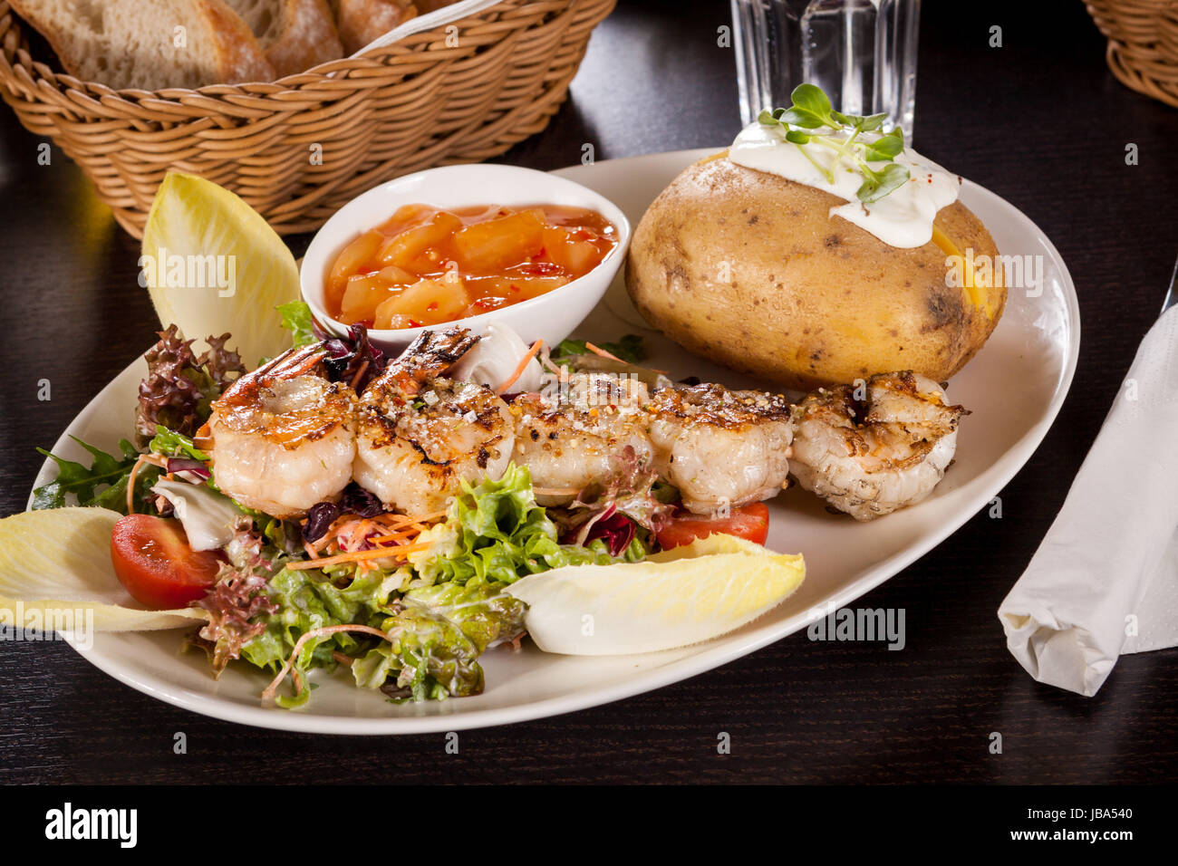 Gebratene Garnelen am Spieß auf gemischtem Salat mit Dipp und ...