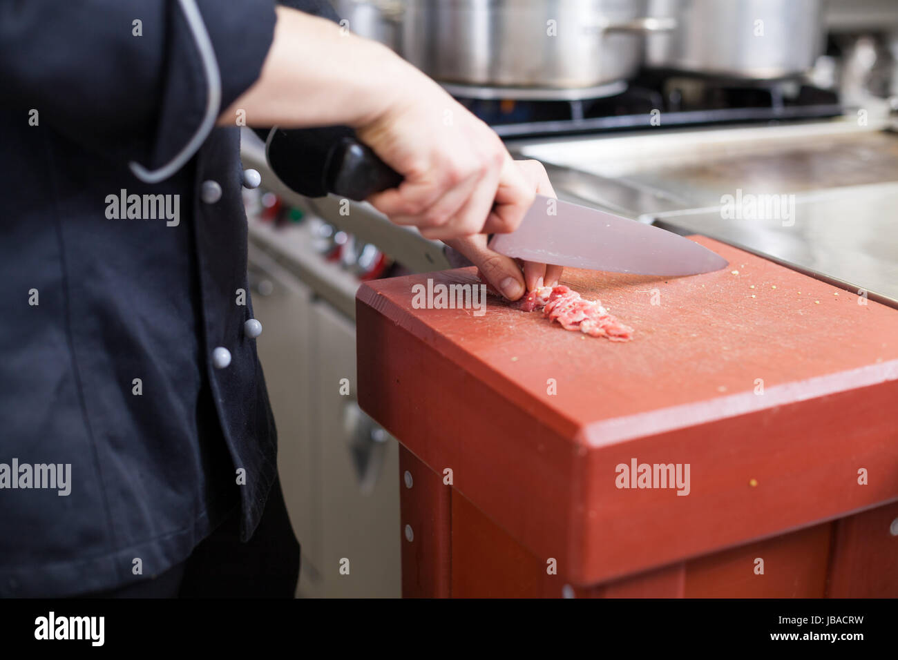 koch schneidet frisches rotes fleisch in der restaurant küche gastronomie lebensmittel arbeit kochen Stock Photo