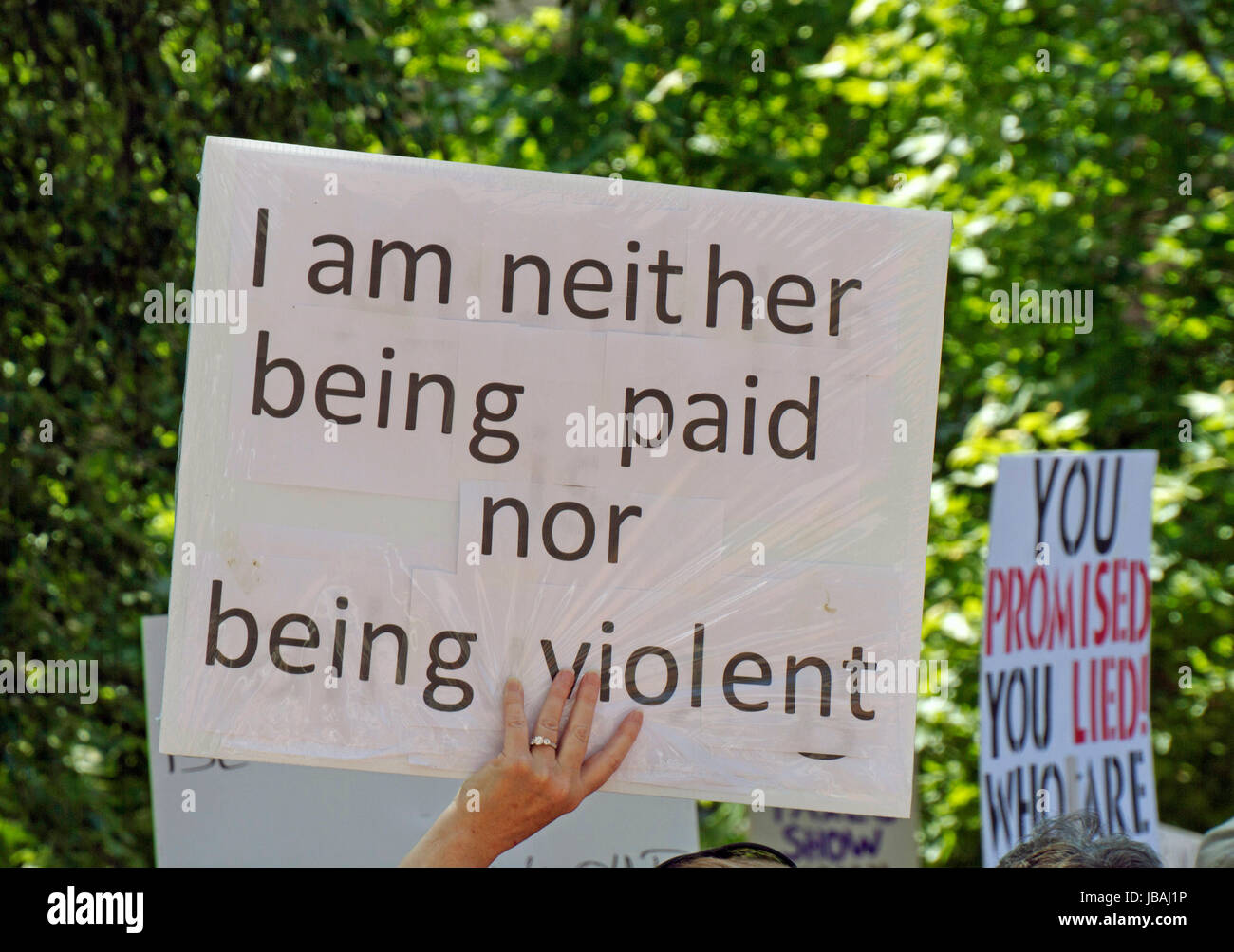 Asheville, North Carolina, USA - June 3, 2017: Close up of a political sign at a peaceful 'March For Truth' rally saying 'I Am Neither Being Paid Nor  Stock Photo