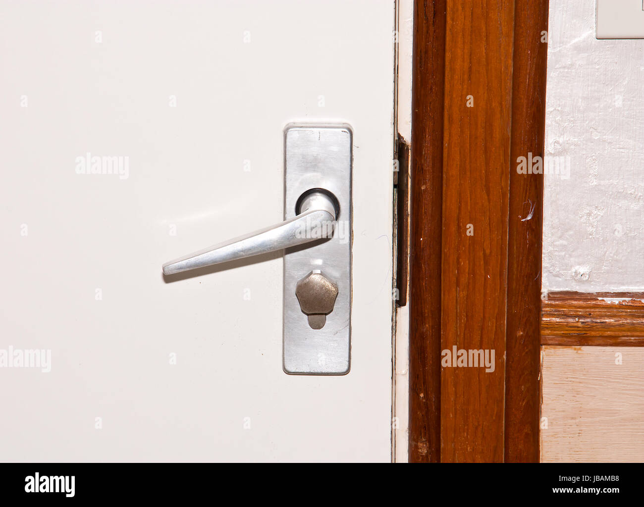 Aluminium door knob on the white door Stock Photo Alamy