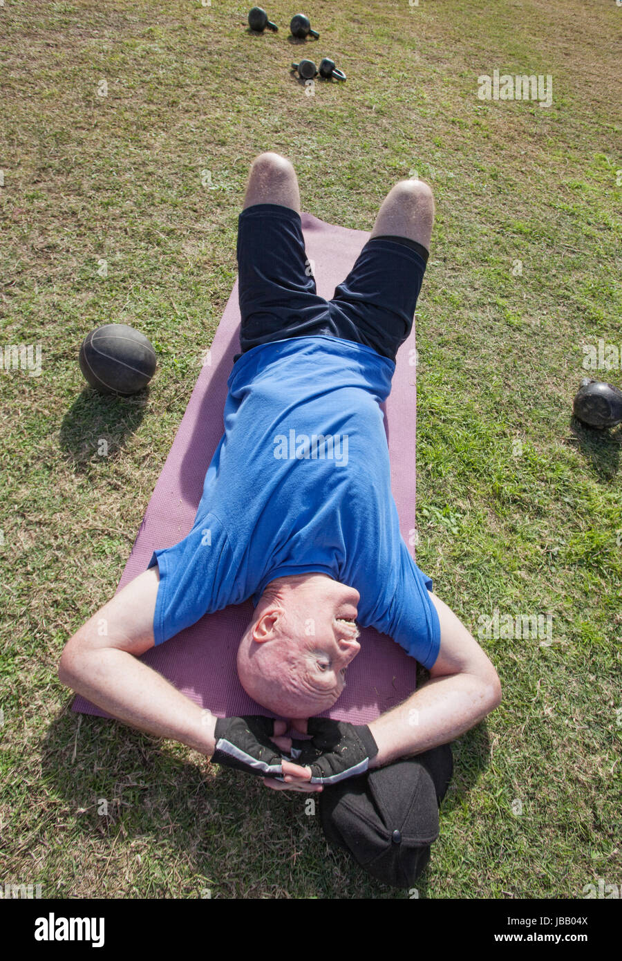 Tired mature man laying on mat outdoors Stock Photo