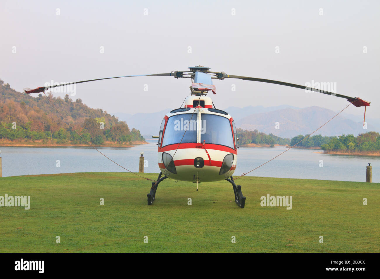 helicopter standing on landing strip in airfield near lake in morning