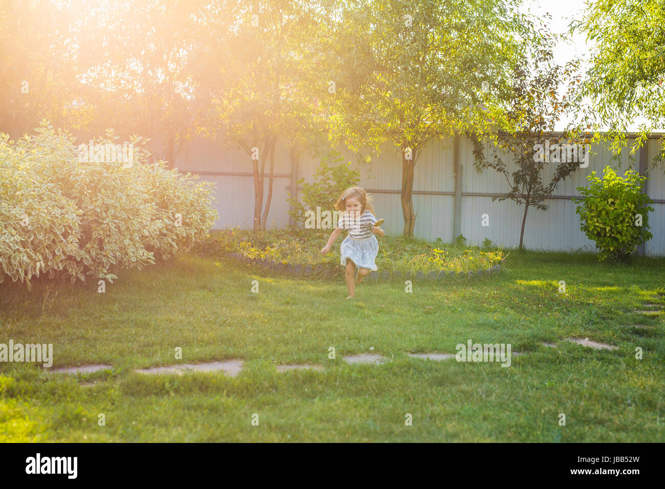 Cute little girl is playing in summer park Stock Photo - Alamy
