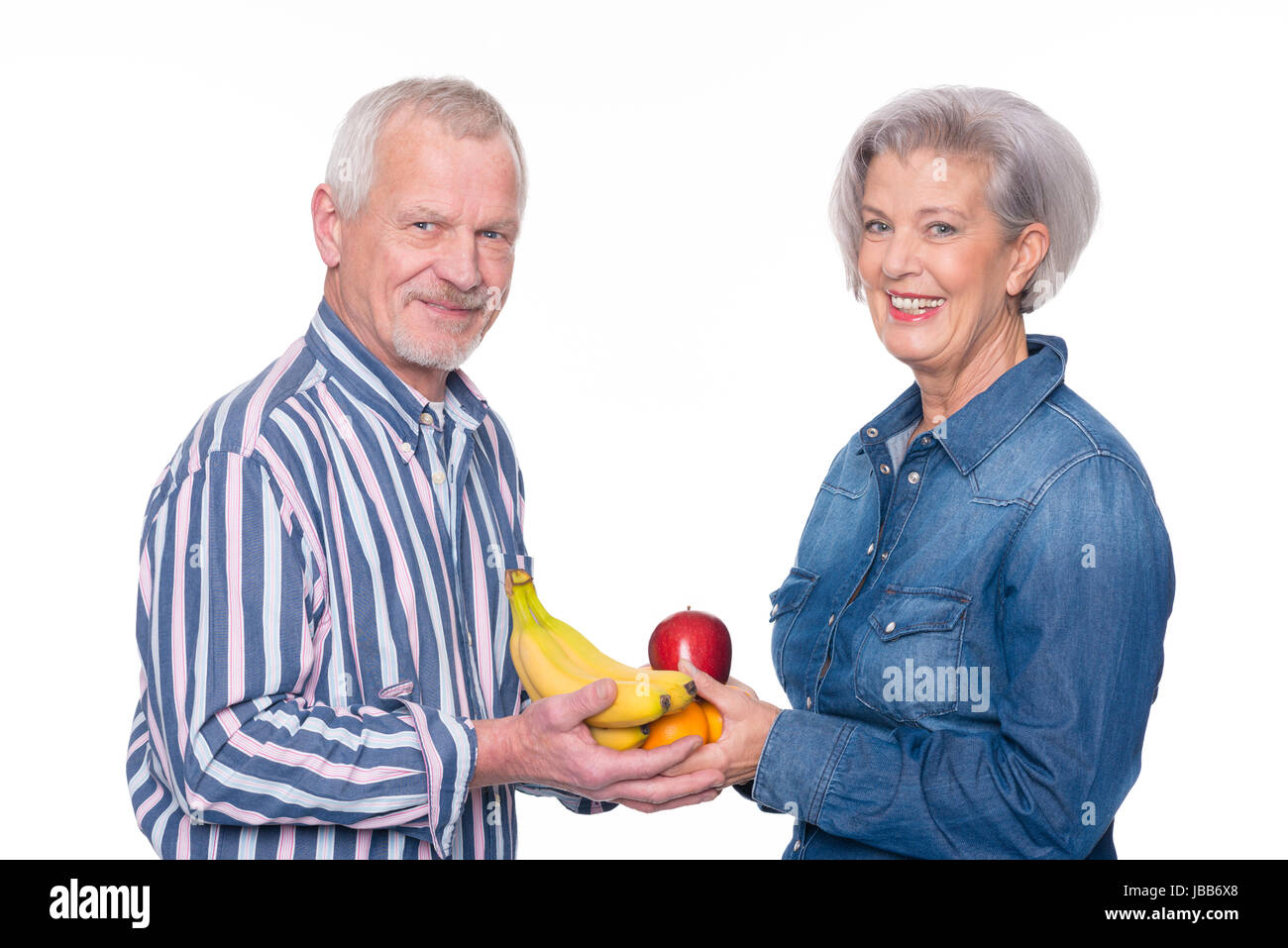 Seniorenpaar mit frischem Obst vor weißem Hintergrund Stock Photo