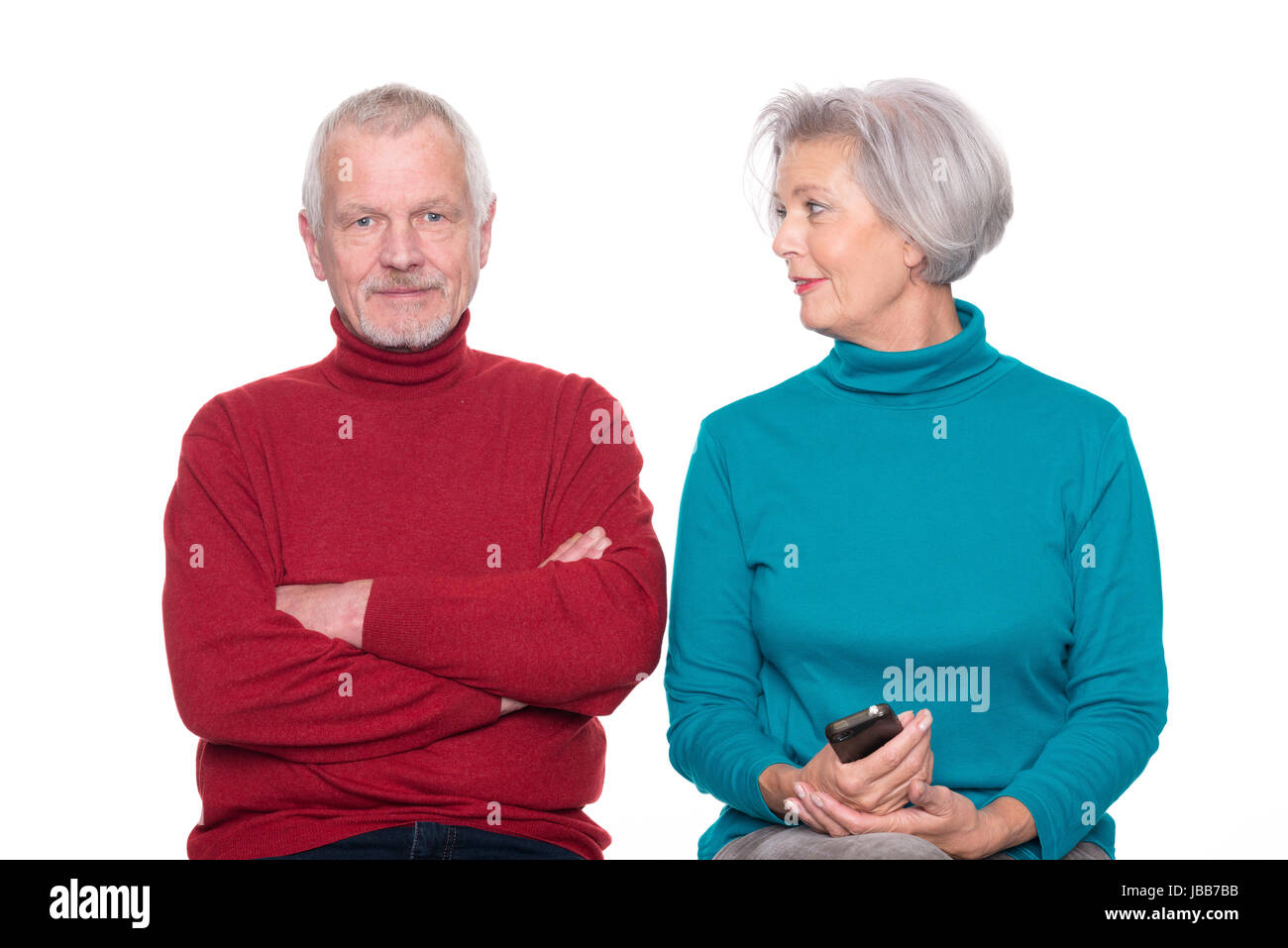 Seniorenpaar mit Smartphone vor weißem Hintergrund Stock Photo