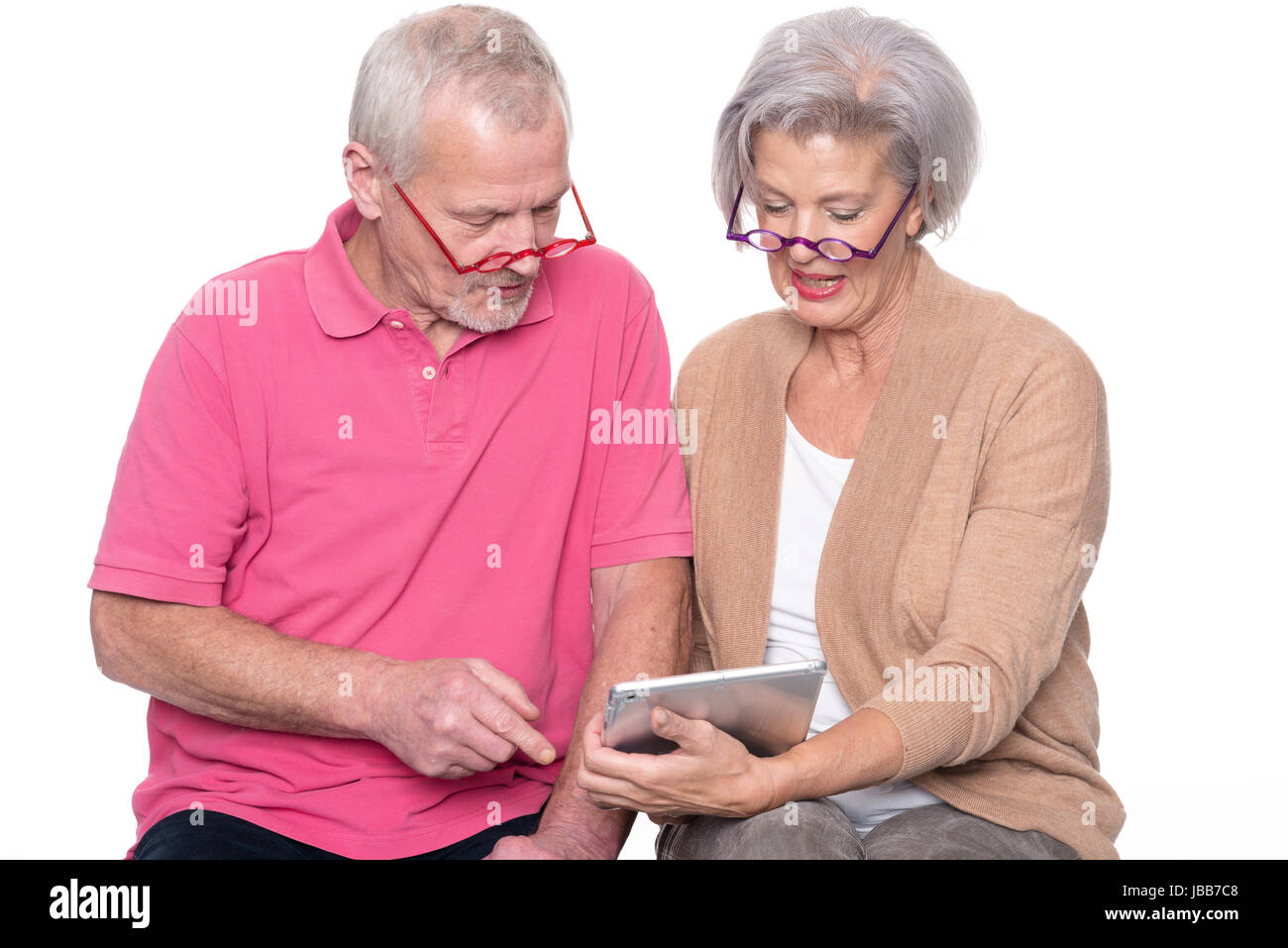 Seniorenpaar mit Tablet vor weißem Hintergrund Stock Photo