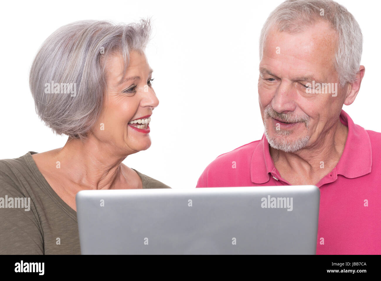 Seniorenpaar mit Computer vor weißem Hintergrund Stock Photo