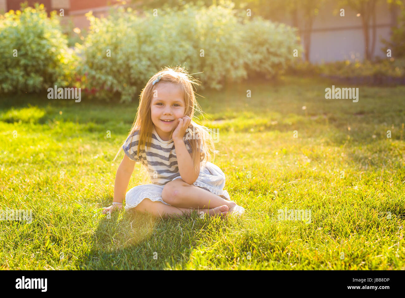 Cute little girl is playing in summer park Stock Photo - Alamy