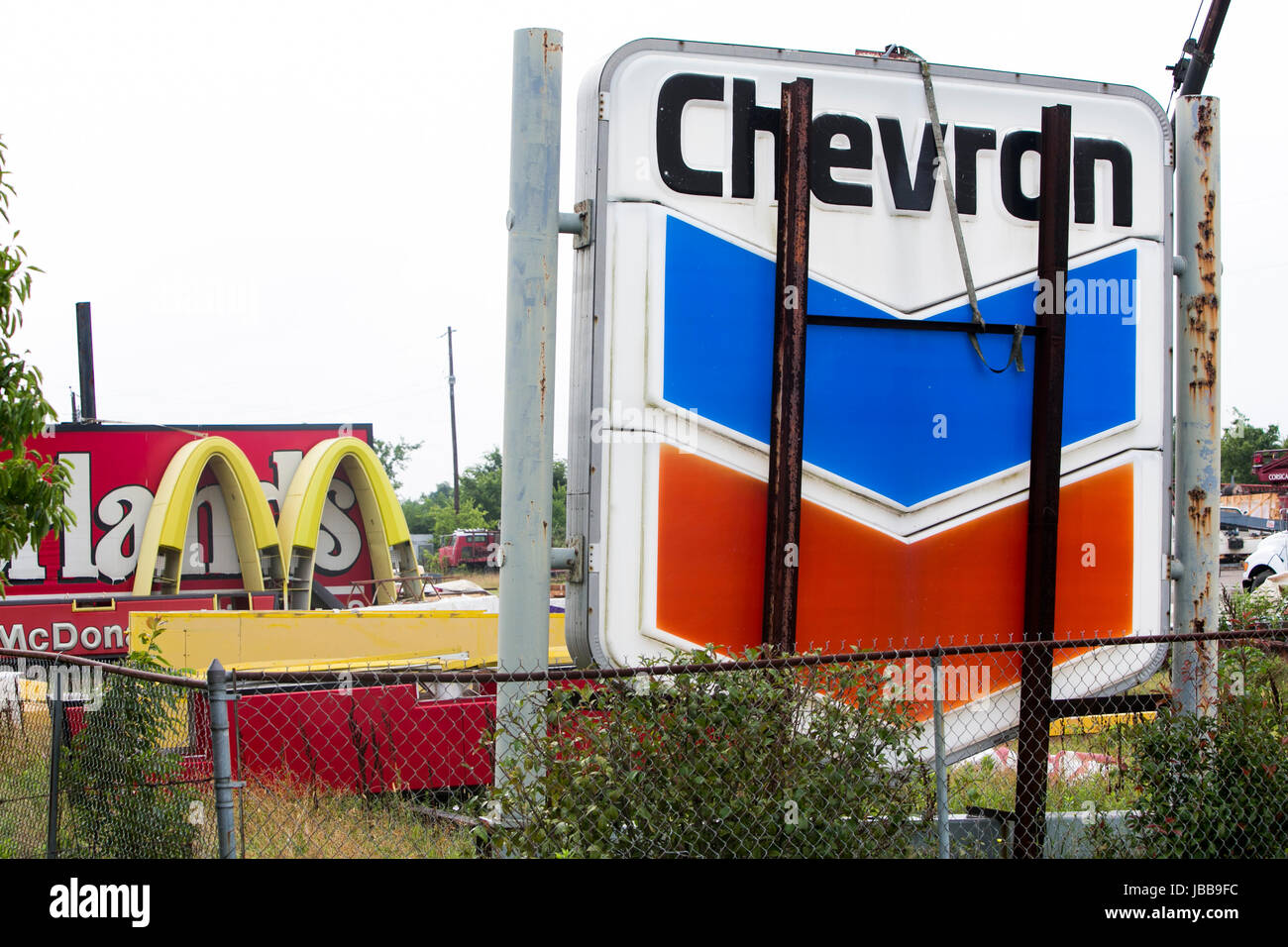 A Chevron and McDonald's logo sign in a junk yard in Corsicana, Texas, on May 29, 2017. Stock Photo