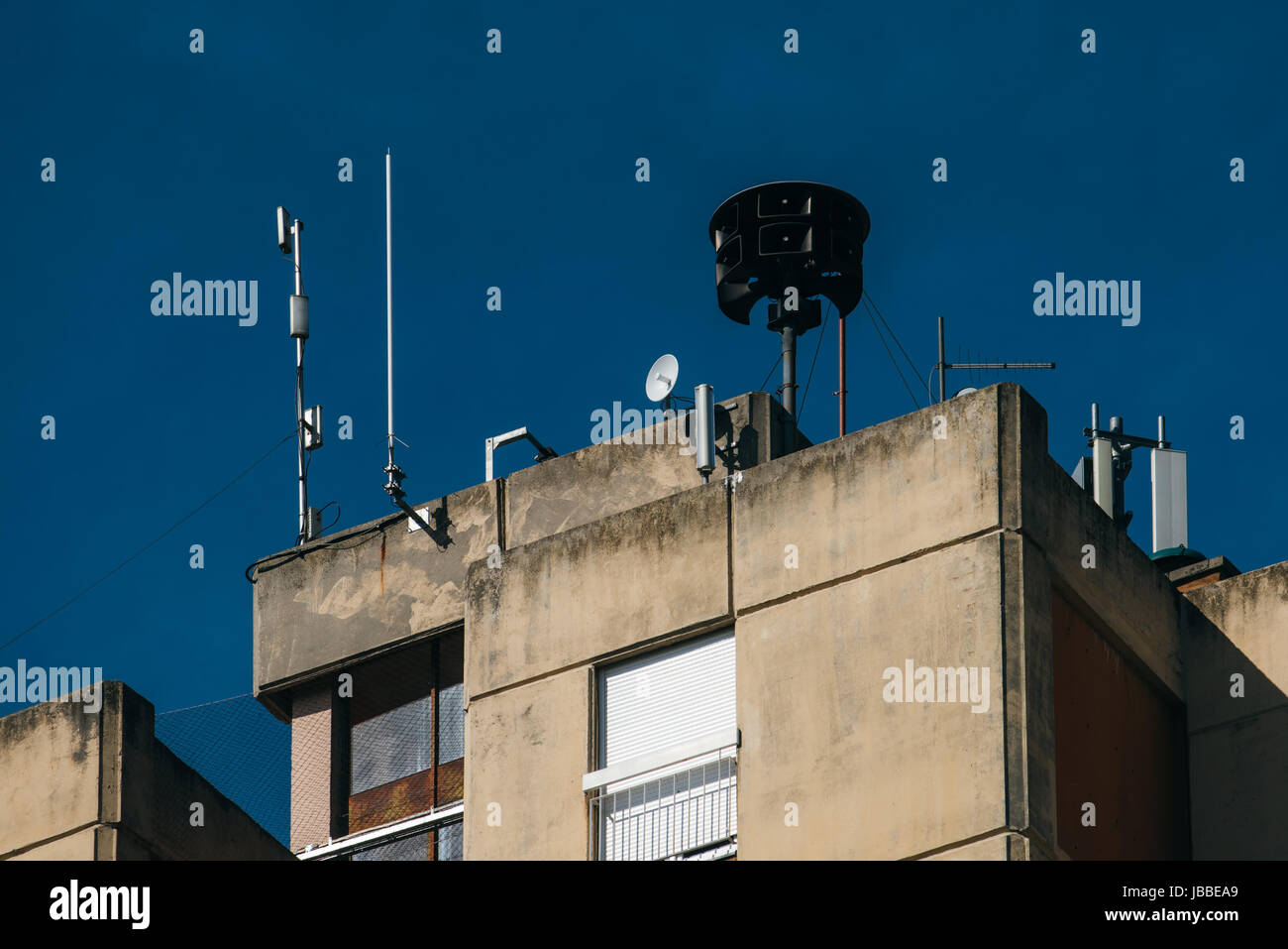 Civil defense siren on top of apartment building, also known as air raid siren, provides emergency warning of approaching danger such as tornadoes Stock Photo