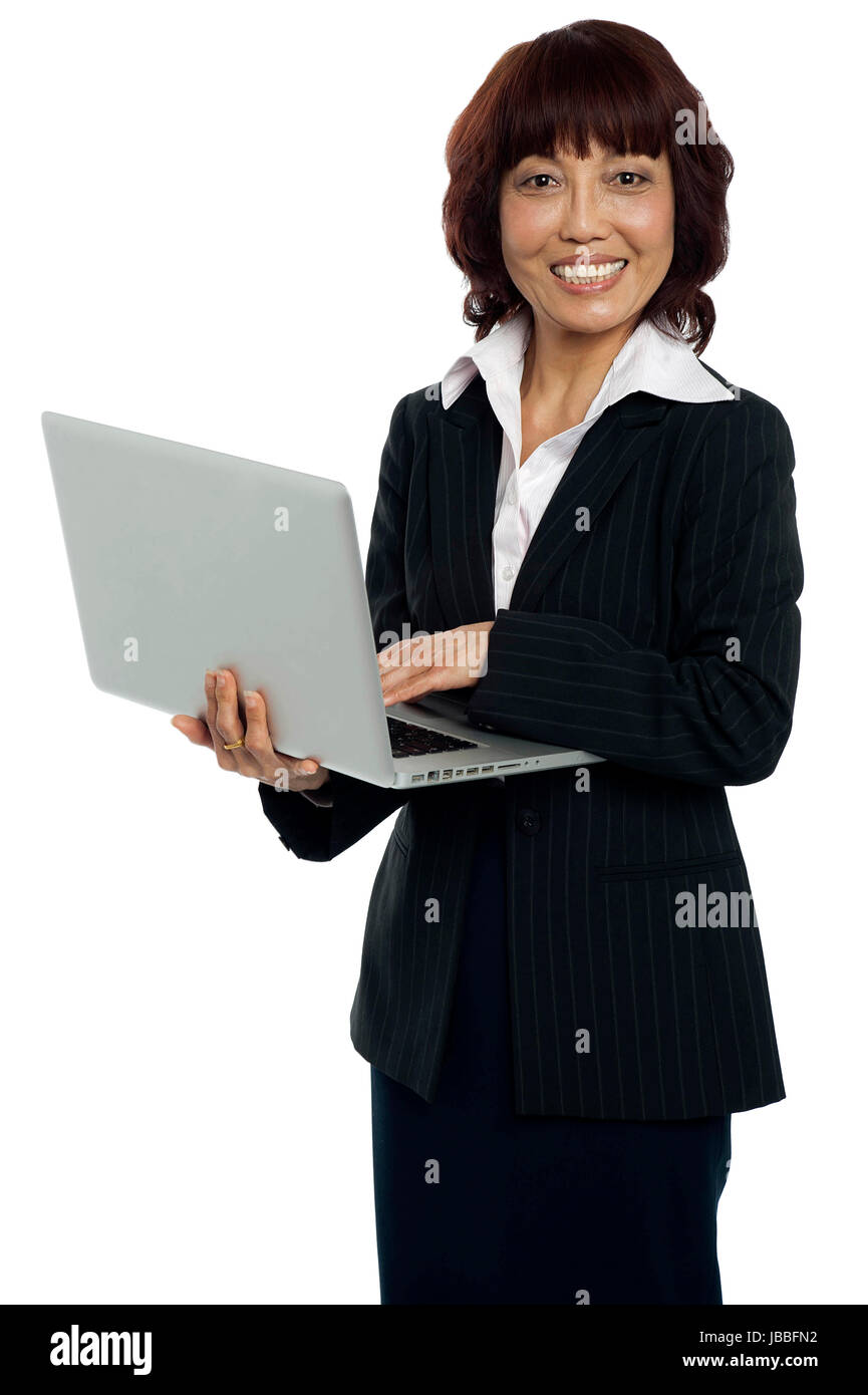 Portrait of a businesswoman working on laptop. Looking at camera and ...