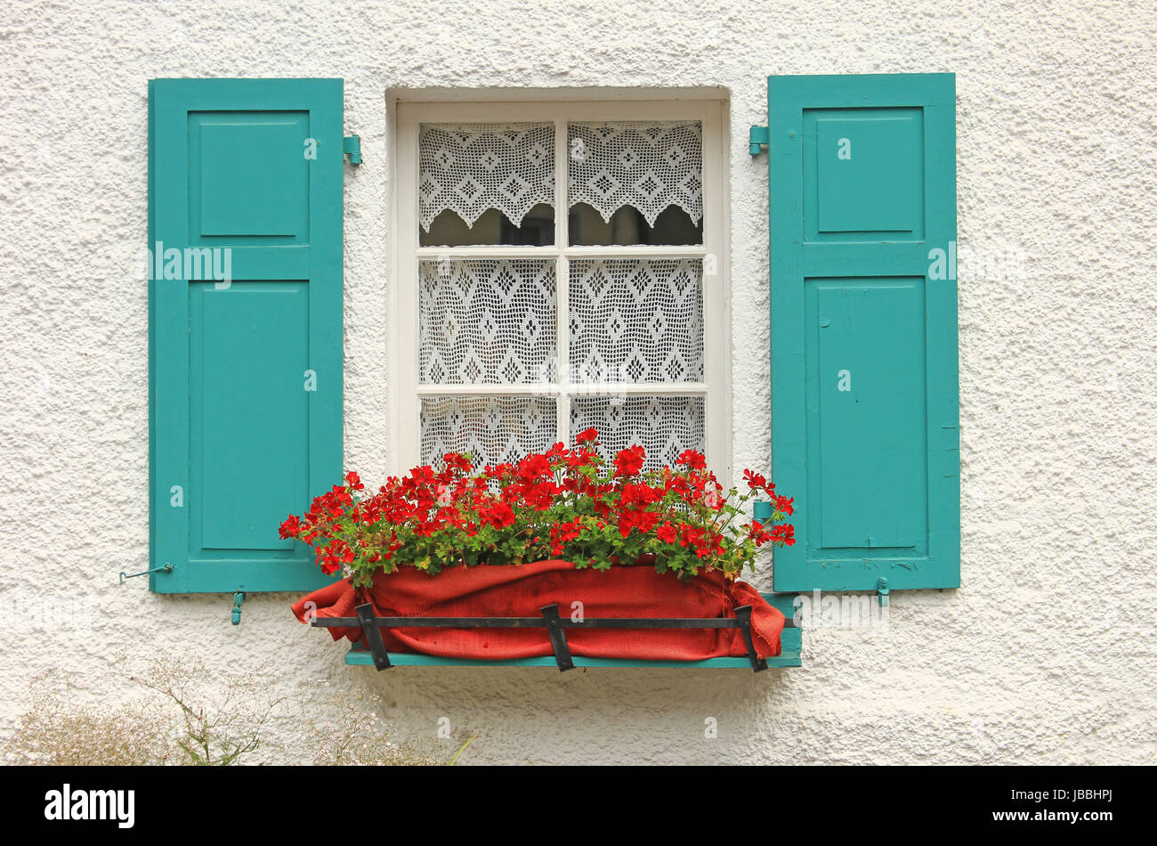 Dekoratives Holzfenster mit Blumenschmuck und grünen Fensterläden in Monreal, Eifel, Rheinland-Pfalz, Deutschland Stock Photo