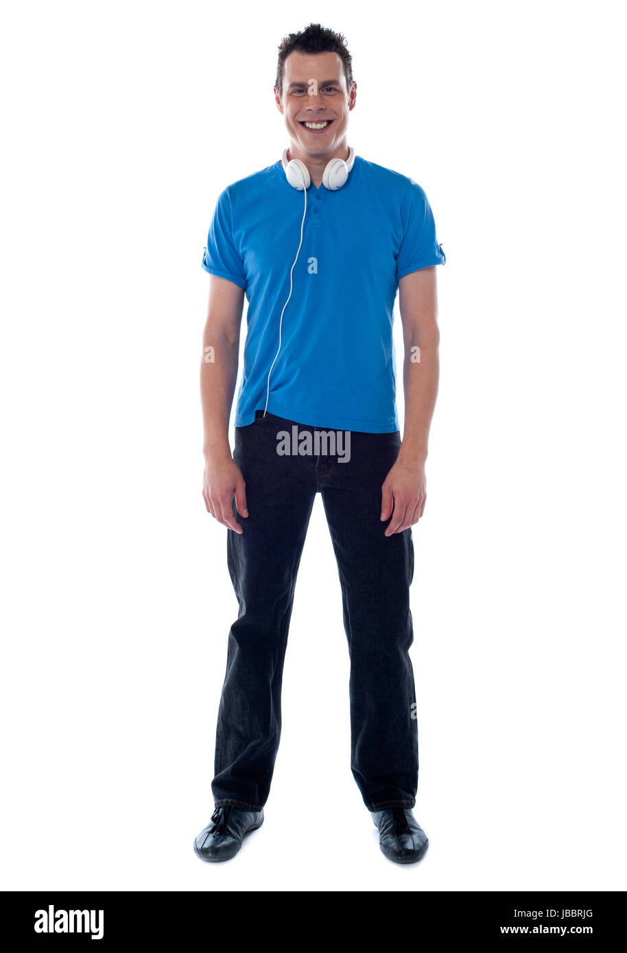 Confident young man standing with headphones around his neck Stock