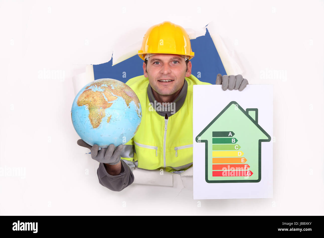 Tradesman holding a globe and an energy efficiency rating chart Stock Photo