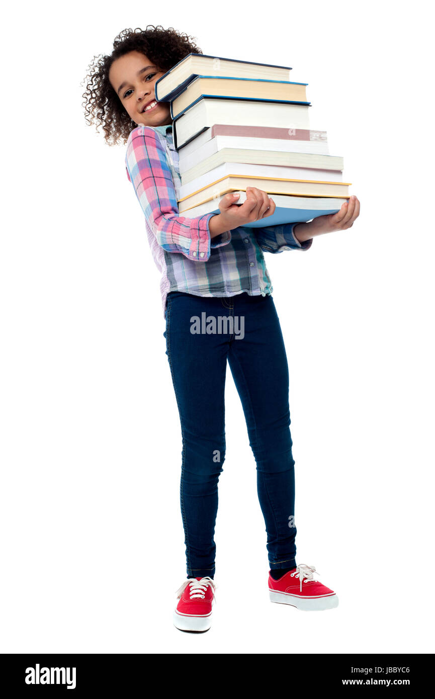 Little girl holding pile of school books grinning happily Stock Photo ...